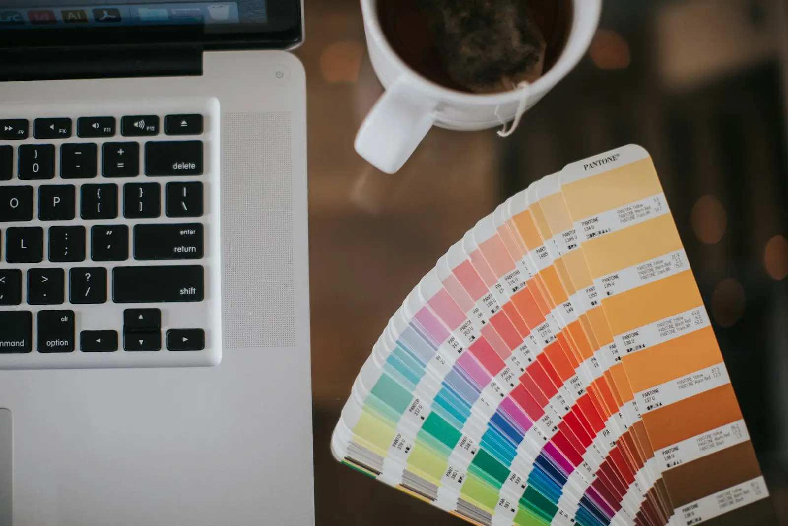 Color swatches beside a designer's laptop and coffee