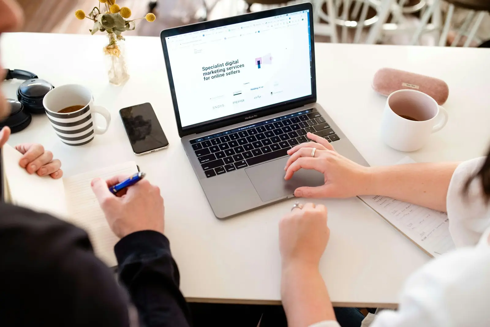 Two collaborators reviewing a website together on a laptop